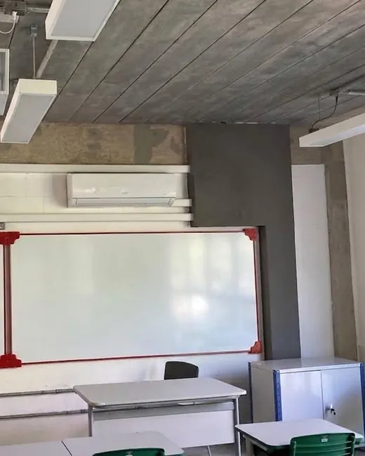 Sala com projetor e unidade de ar-condicionado instalada em altura.