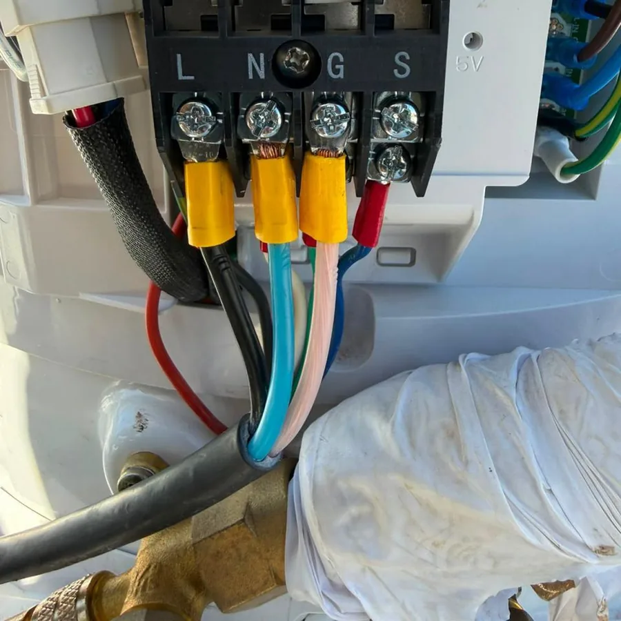 Terminais elétricos identificados e cabeamento conectado à régua da unidade.